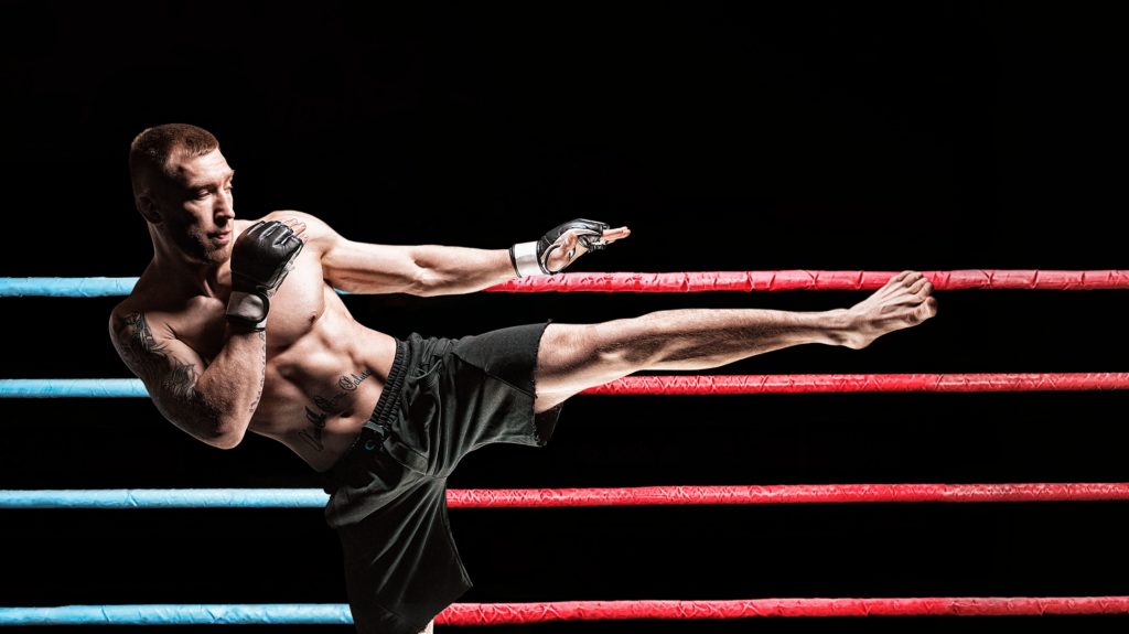 Kickboxer posing in the ring. Middle Kick.