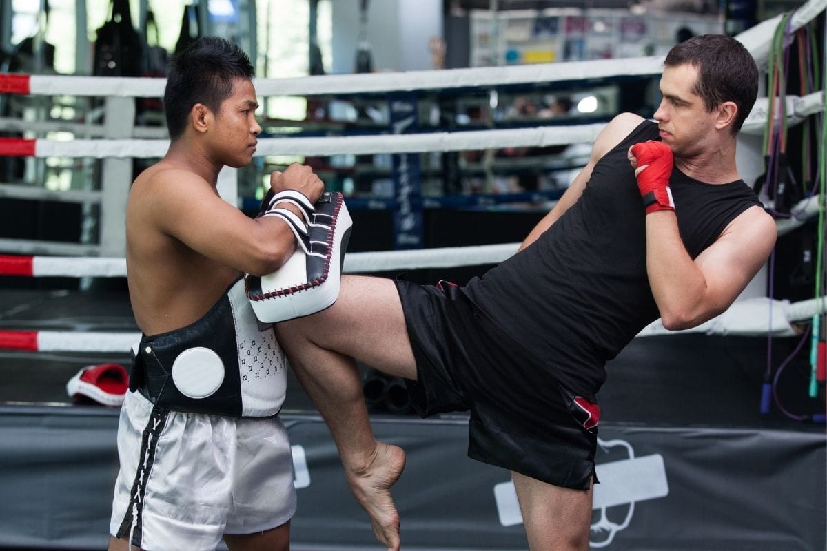man and his cocah practicing muay thai knee strikes