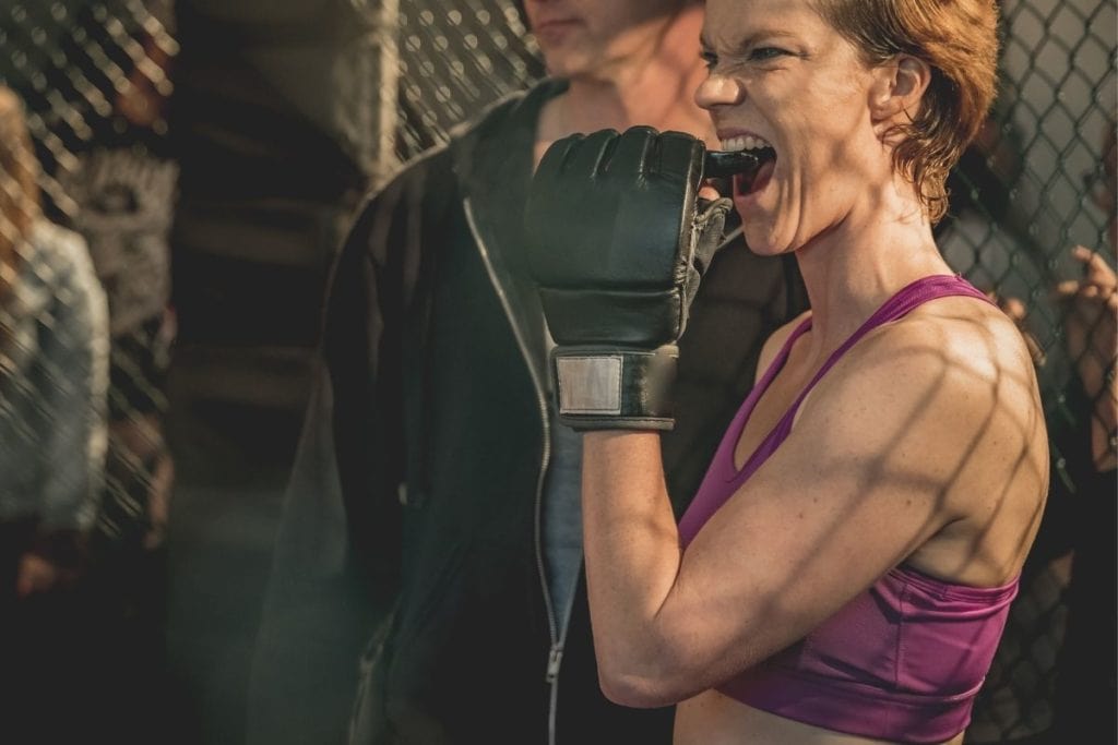 mma fighter putting a mouthguard into her own mouth