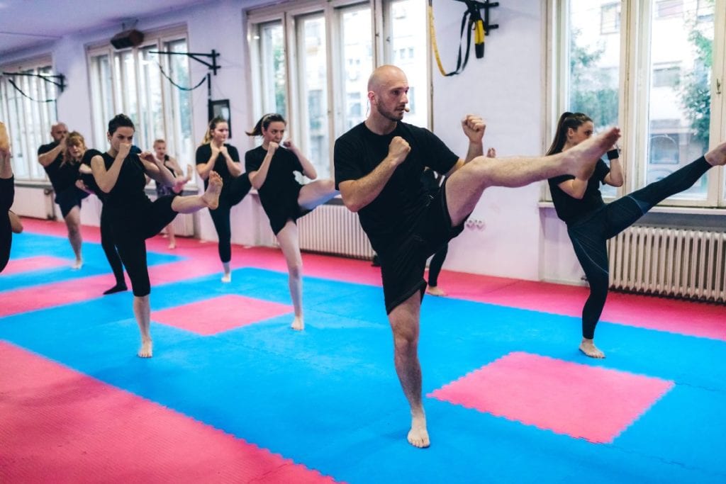 bunch of man and woman in kickboxing class